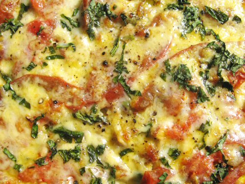 Omelet topped with cheese and basil