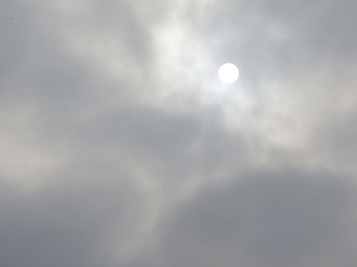 The Sun breaking through fog and clouds as a perfect white disk